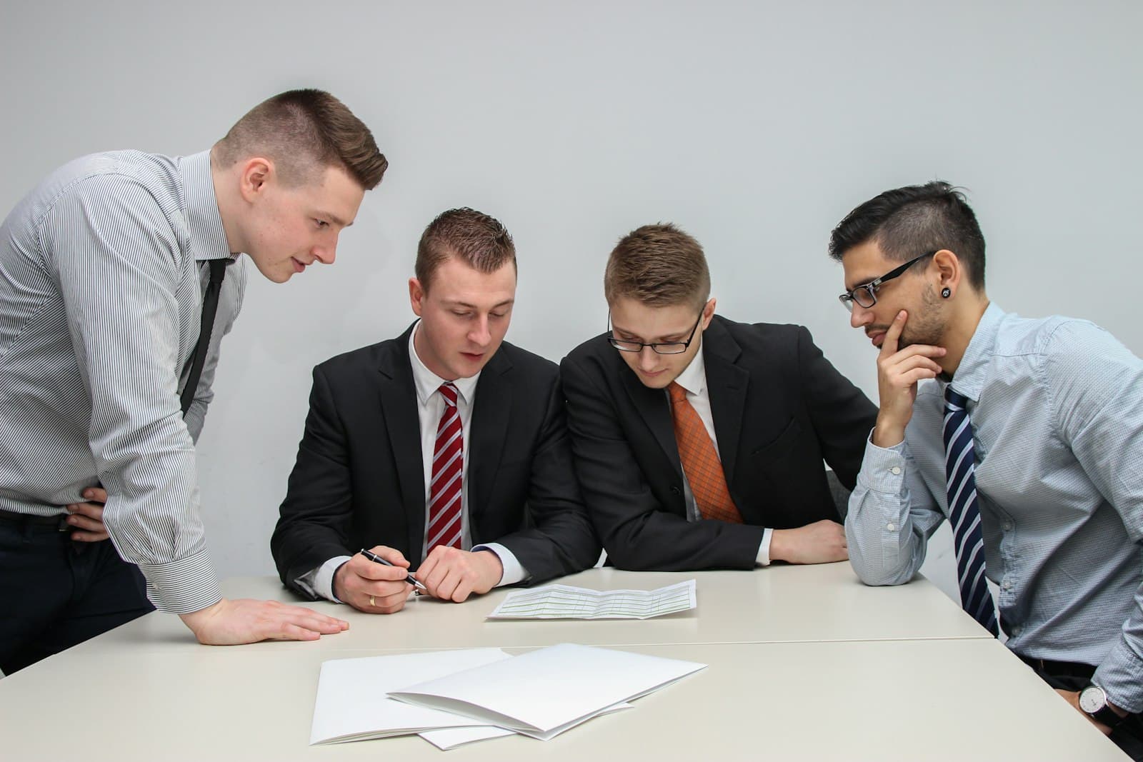 A team in business attire reviewing documents together around a table