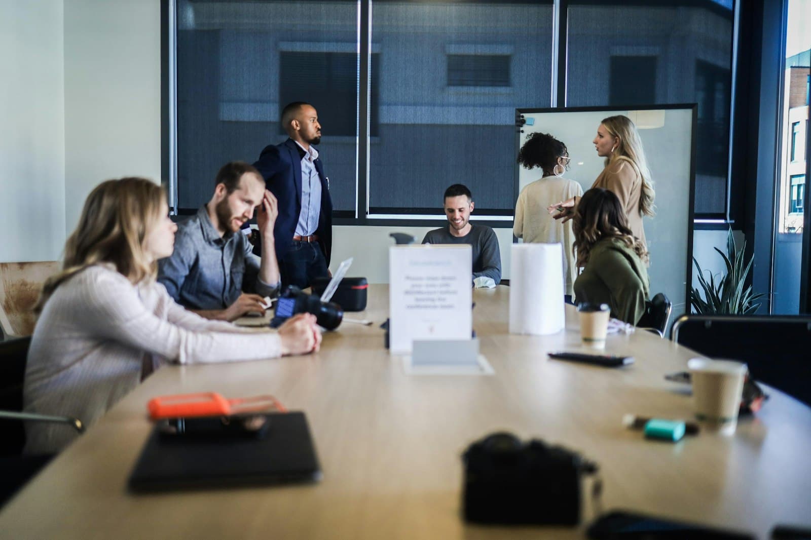 A busy meeting room with a team collaborating around a whiteboard