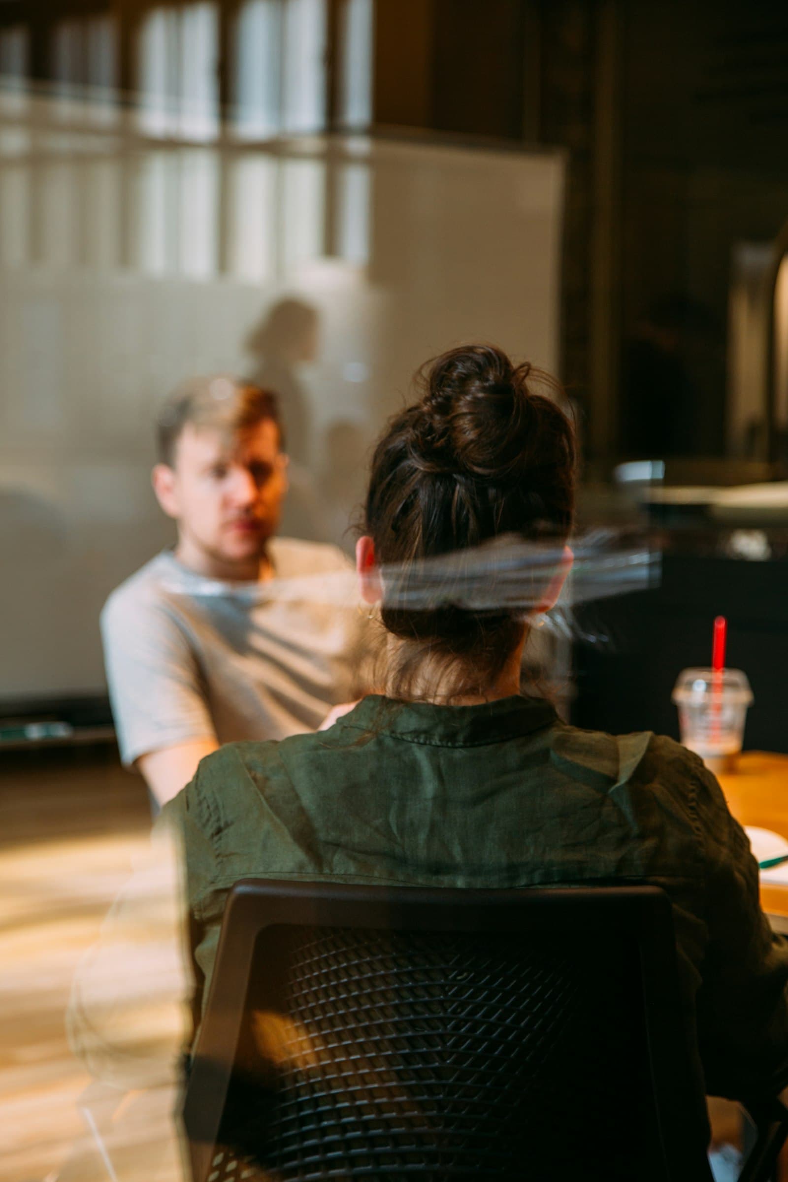 Two colleagues in a candid one-on-one conversation in a modern office