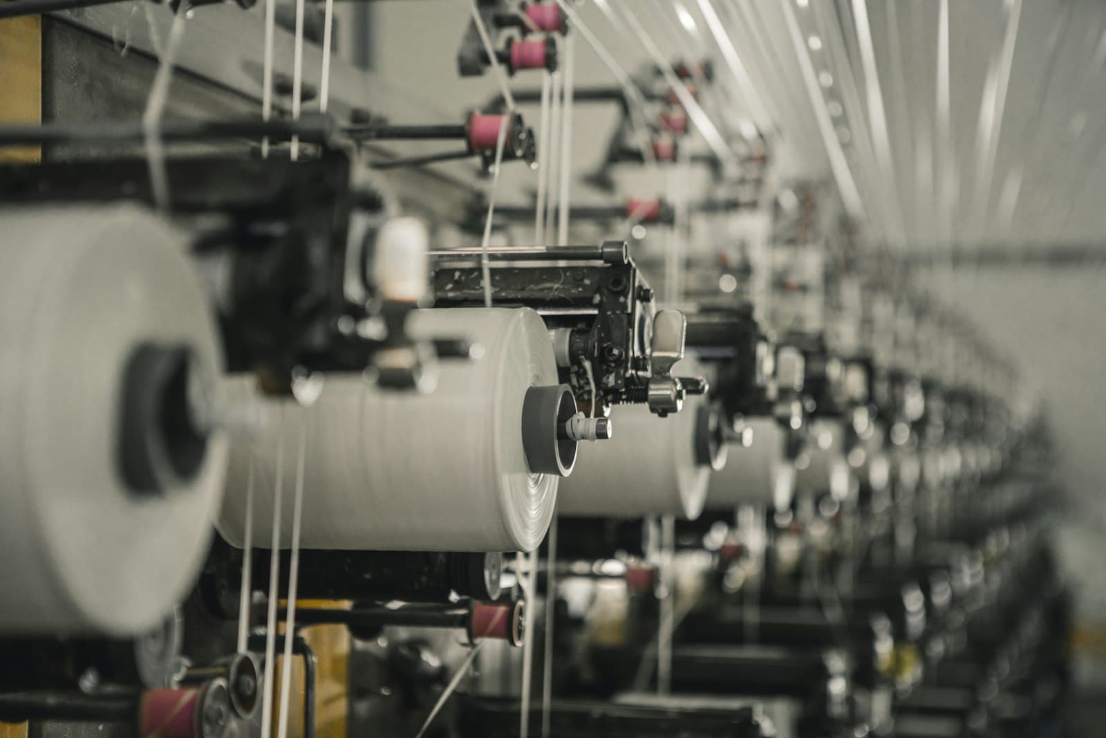 Close-up of thread spools on textile production machinery